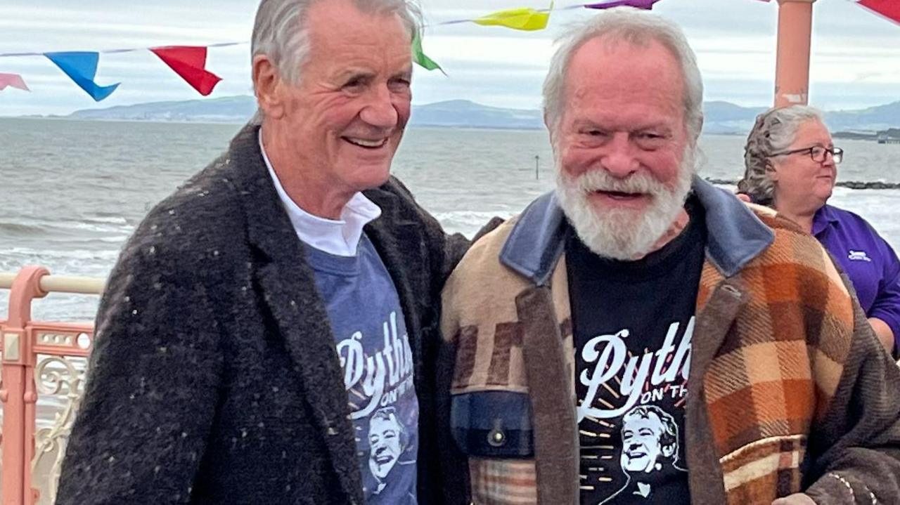 Michael Palin and Terry Gilliam in Colwyn Bay with beach behind them