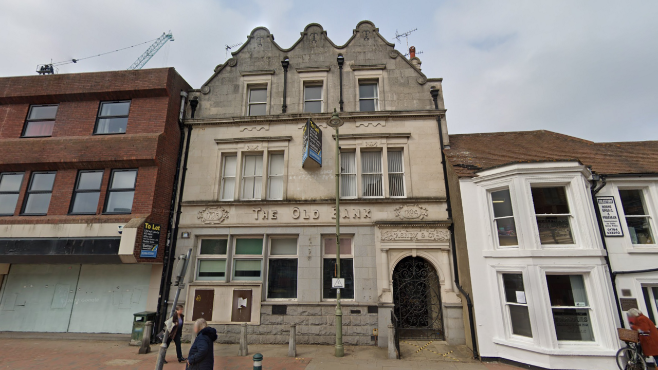 A once proud grey 19th Century bank lies empty with a to let sign outside. 