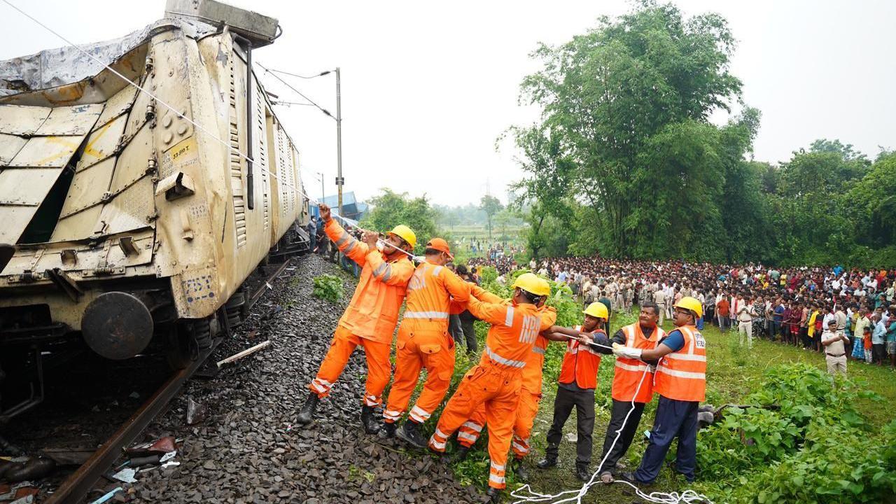 Rescue officials seen carrying out relief work at the site of the accident as a crowd watches on