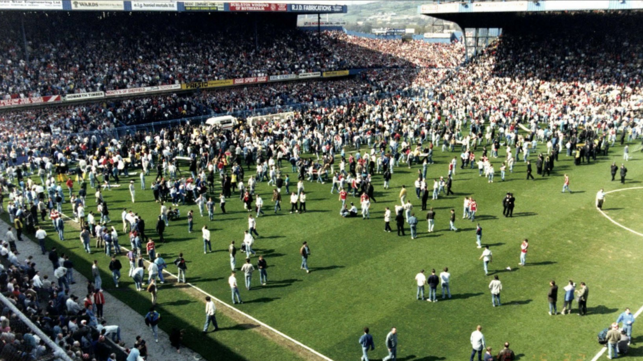 View of people standing on the pitch in the aftermath of the Hillsborough disaster