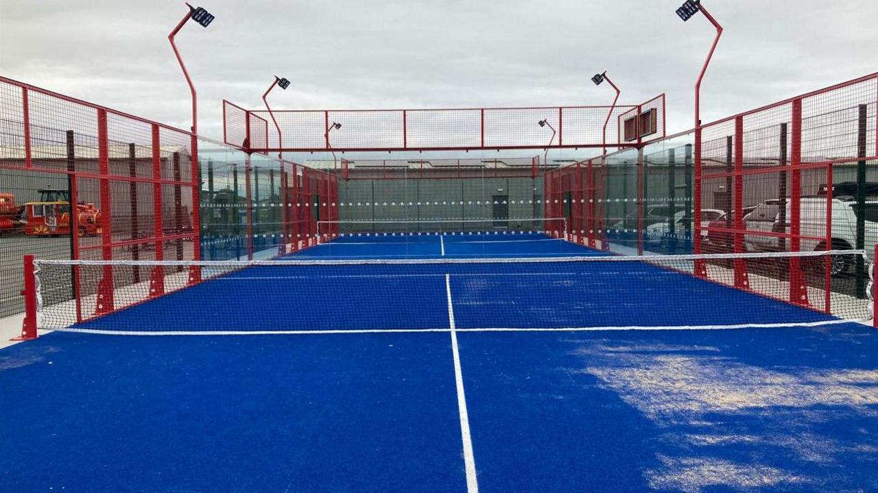 An empty blue and red padel tennis court