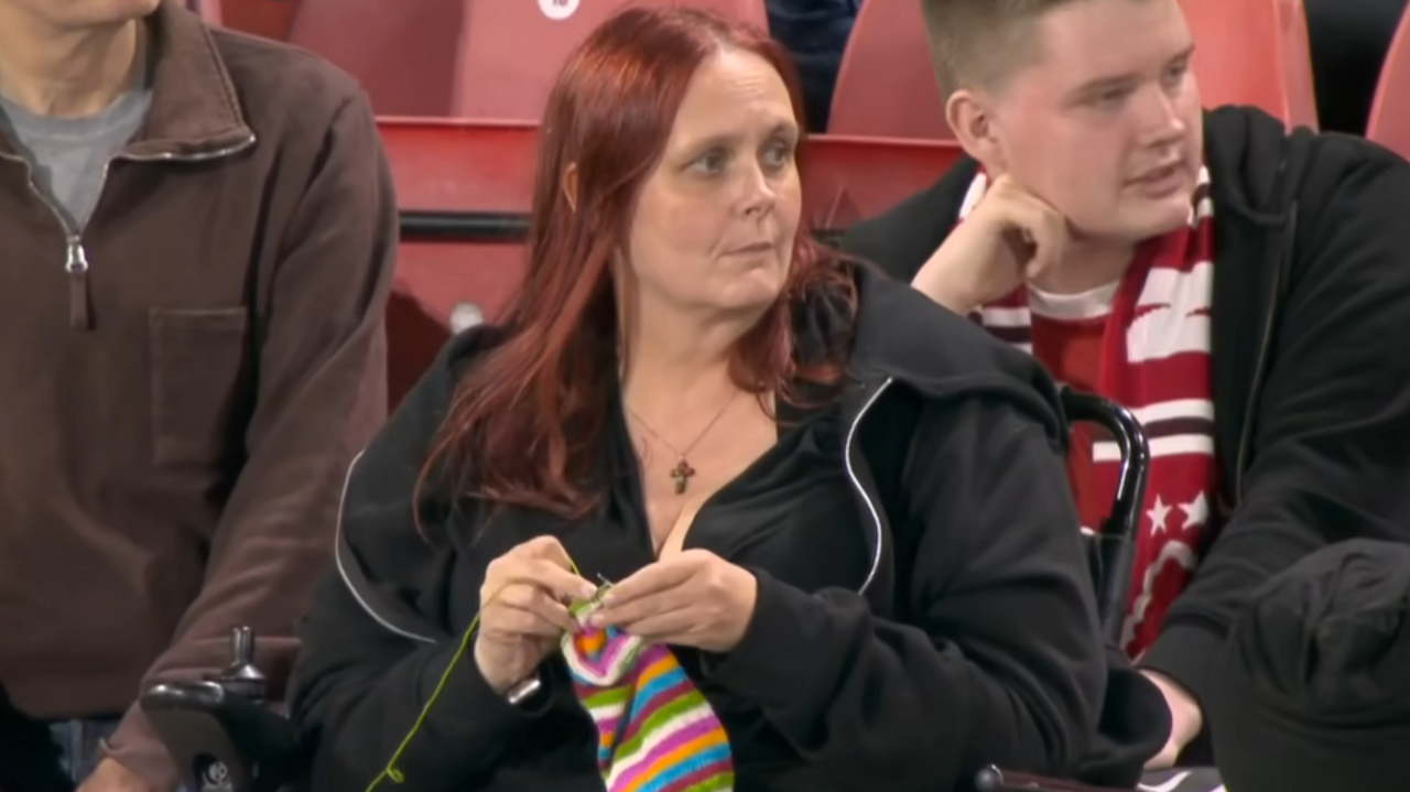 A screengrab of Laura Cameron knitting while watching a football match