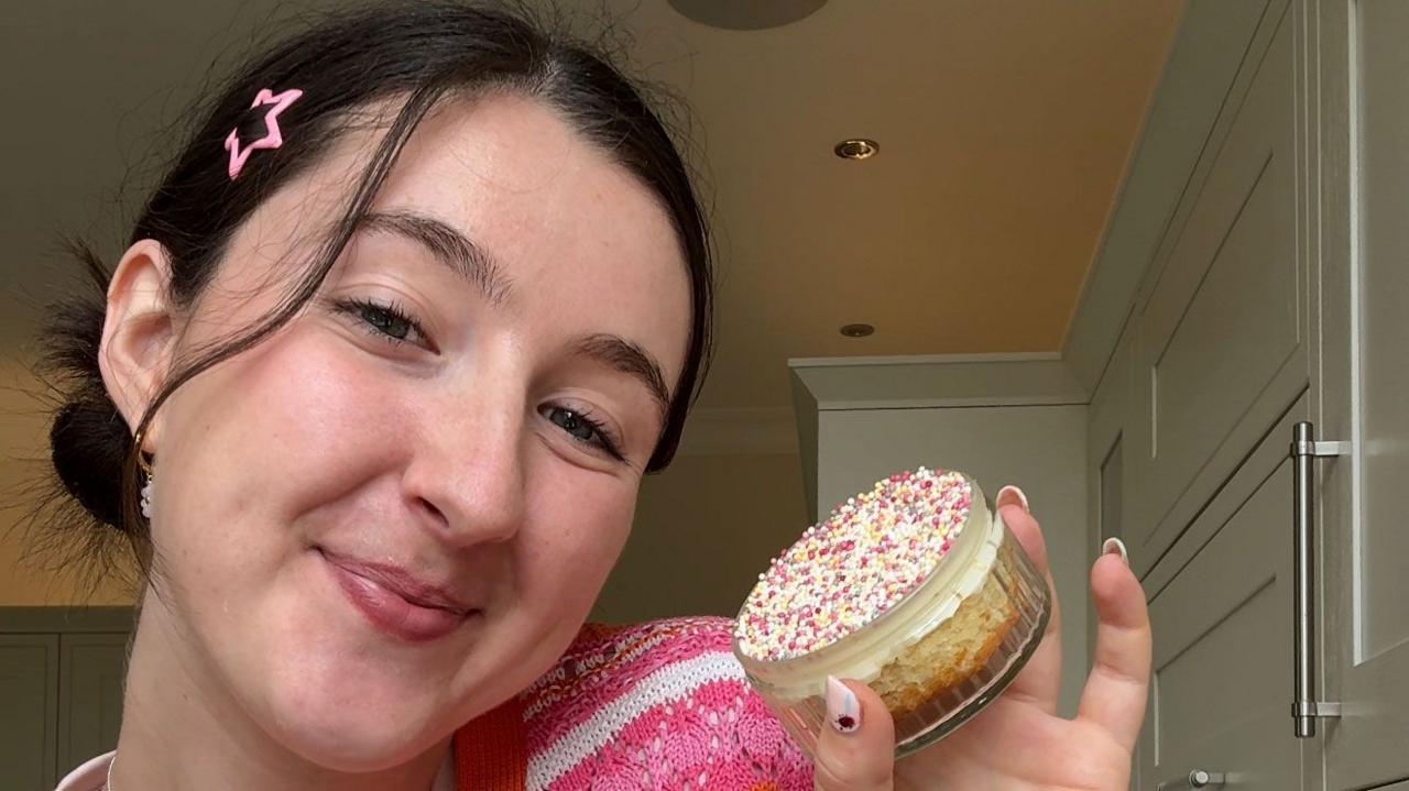 Chloe Rose holds her dot cake up 