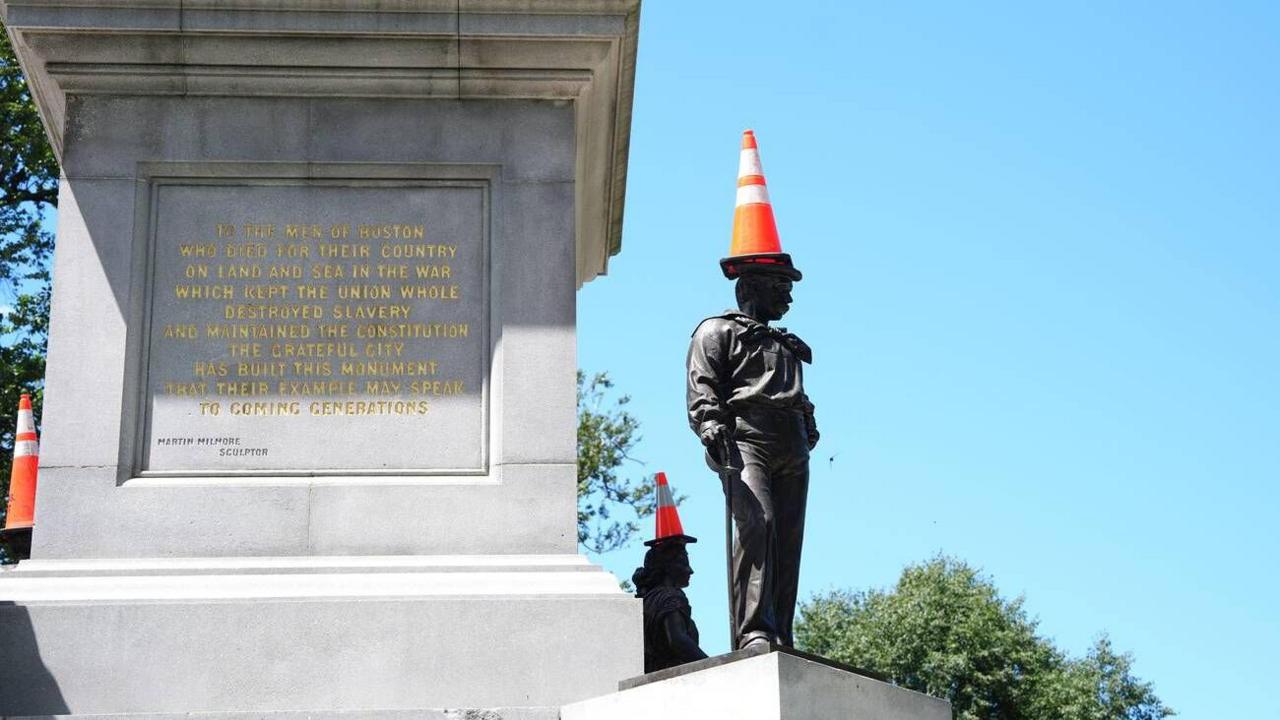 A statue in Boston with an orange traffic cone place on top of its head