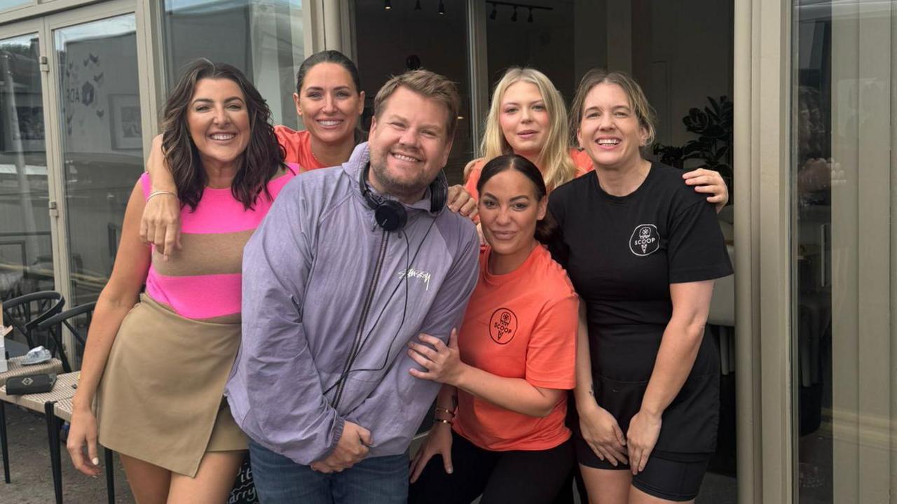 Laura Davenport (far left) and Scoop ice cream store workers pose with James Corden (centre) outside the shop. 