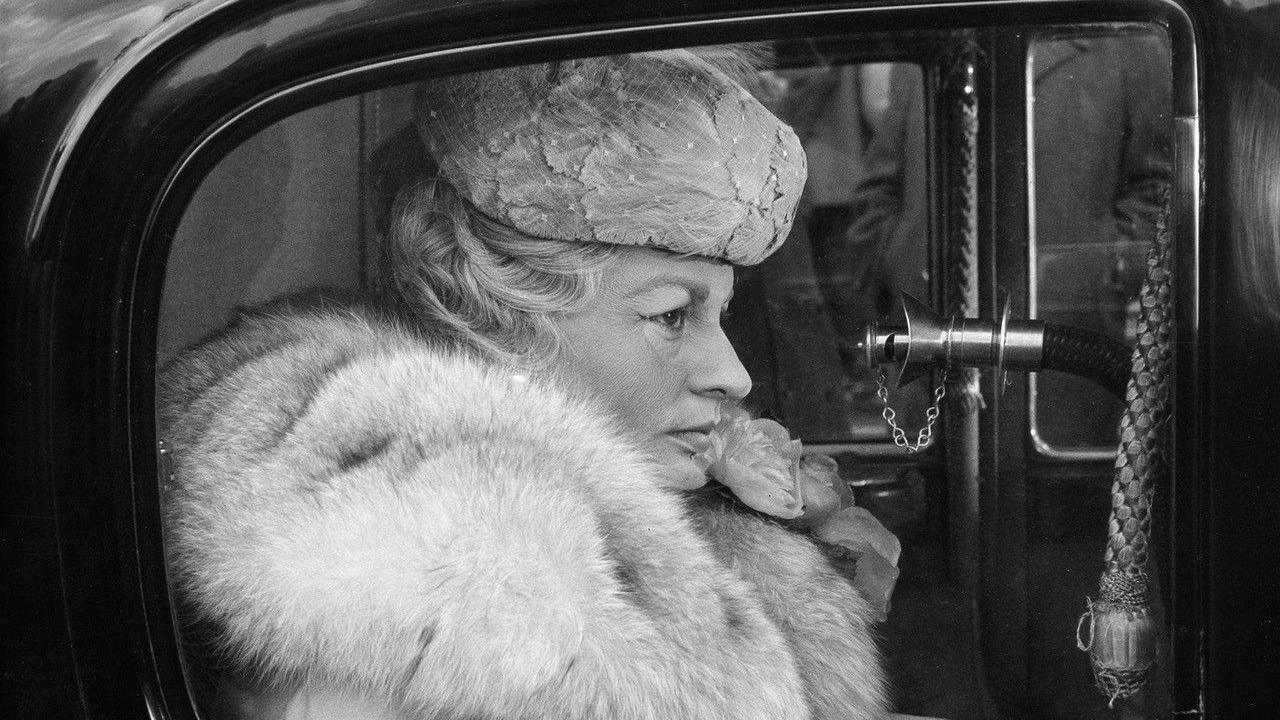 Lady L being transported in a black vehicle. In the photo wrinkles are visible on her face to illustrate her old age.