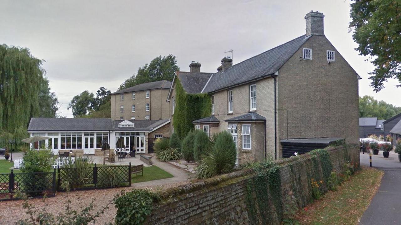 The Quy Mill Hotel and Spa as it looks now - three brick buildings and a single-storey glass-fronted structure