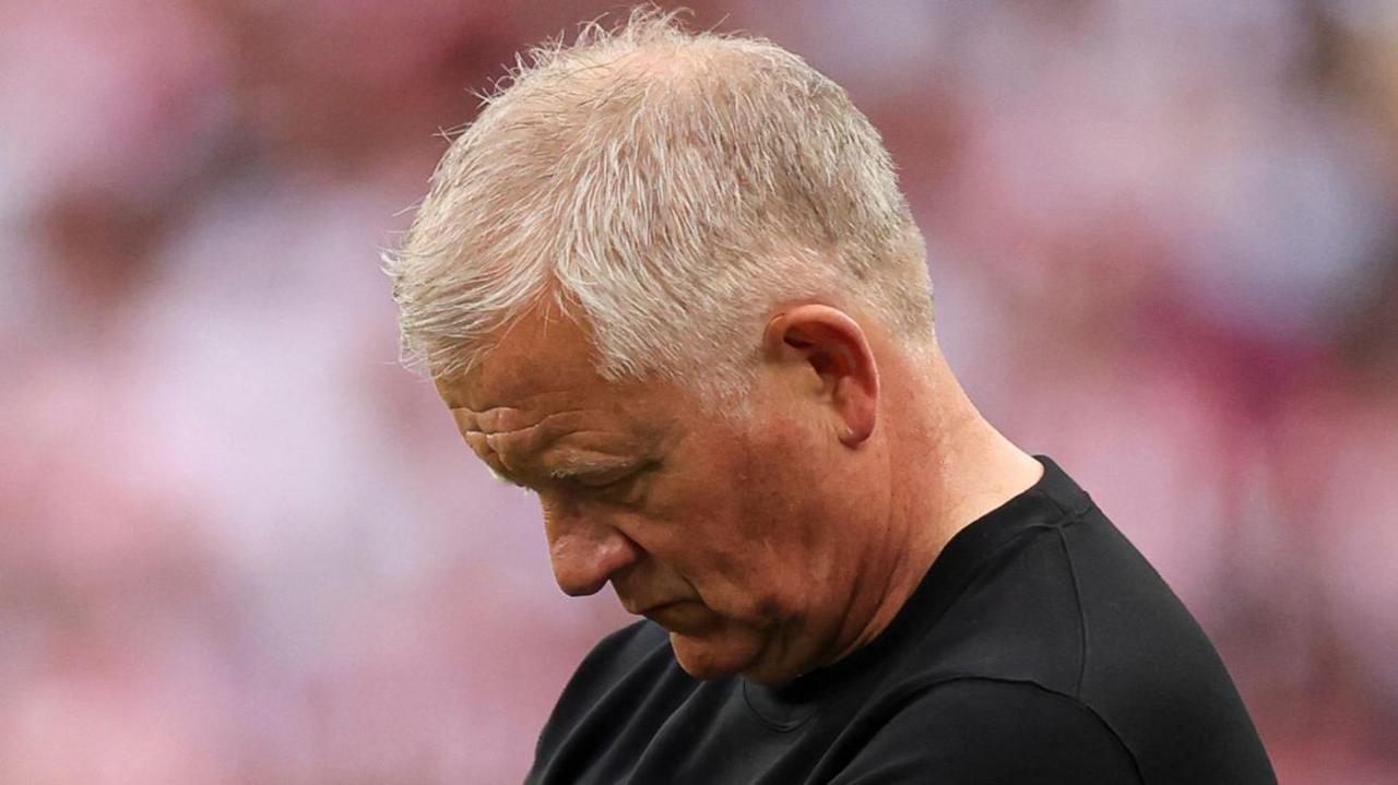 A photo of Chris Wilder looking down