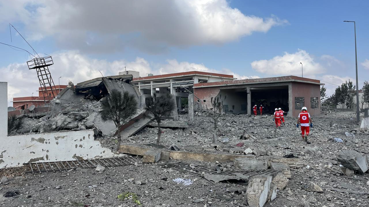 Emergency workers approach the Baraachit Emergency Centre the morning after an Israeli strike. Walls have collapsed and rubble surrounds the building.
