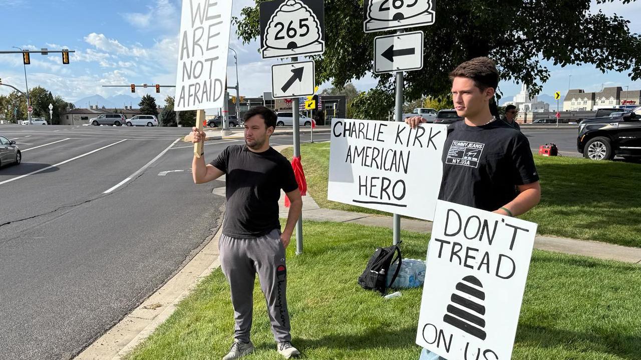 McKinley Shinkle (left) and his cousin, Anthony, hold signs in support of Charlie Kirk near the entrance of the Utah Valley campus