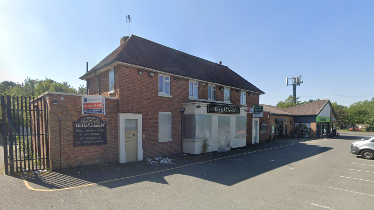 A two-storey pub building with a car park in front