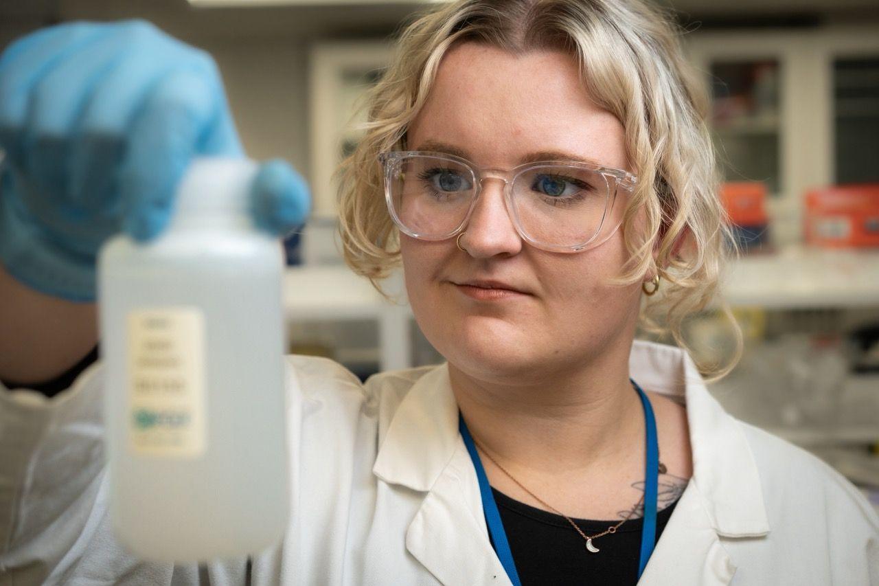 Phd researcher Laura Taylor holds a small bottle of water containing melted water from the iceberg