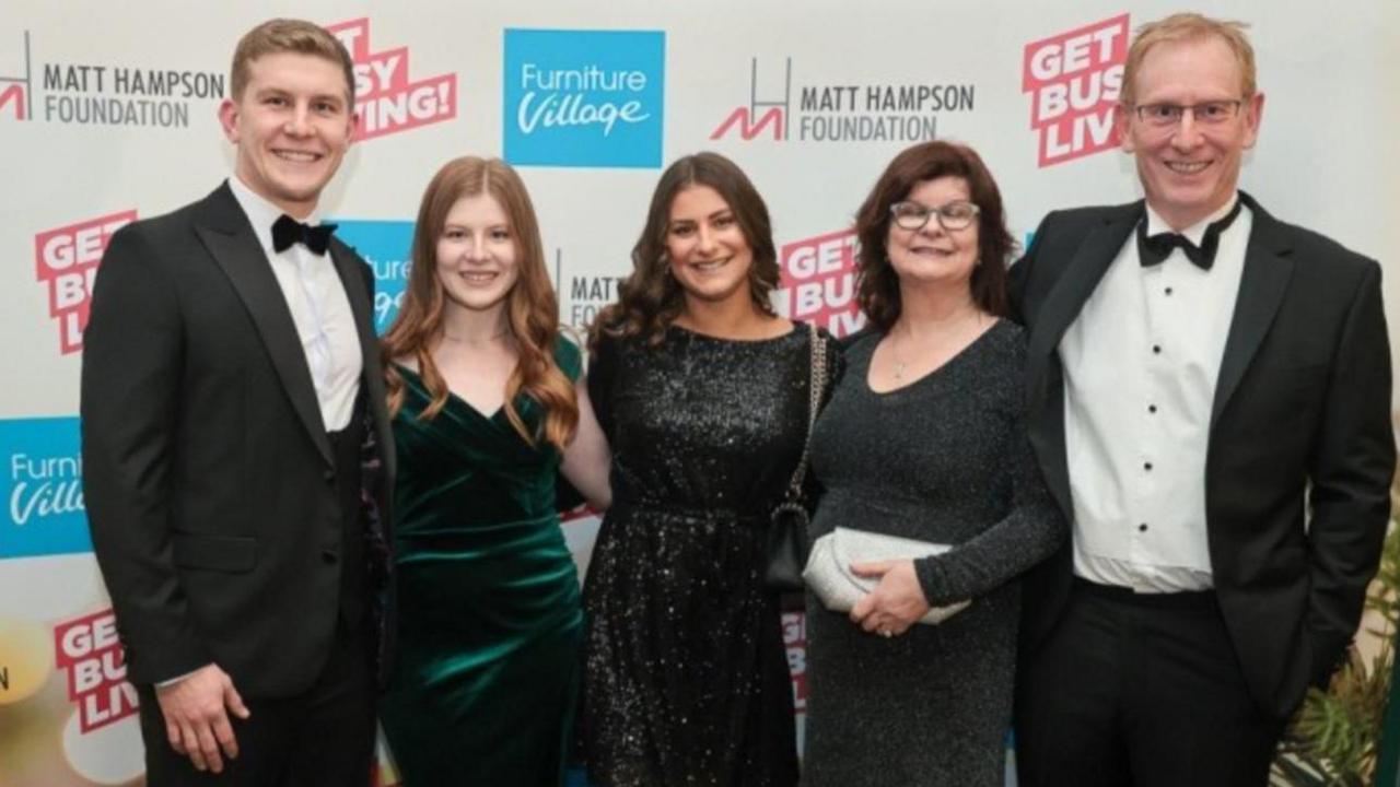 Henry with his sister, Eleanor, girlfriend, Becca, mum, Mary, and dad, Les standing in smart black tie outfits and dresses