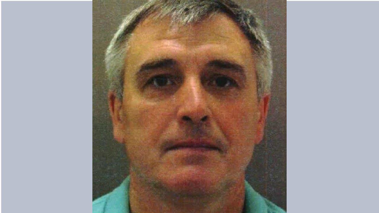 A passport-style image of Denis Sergeev, who used the alias Sergey Fedotov. He is wearing a light green polo top and has greying hair which is tightly cropped