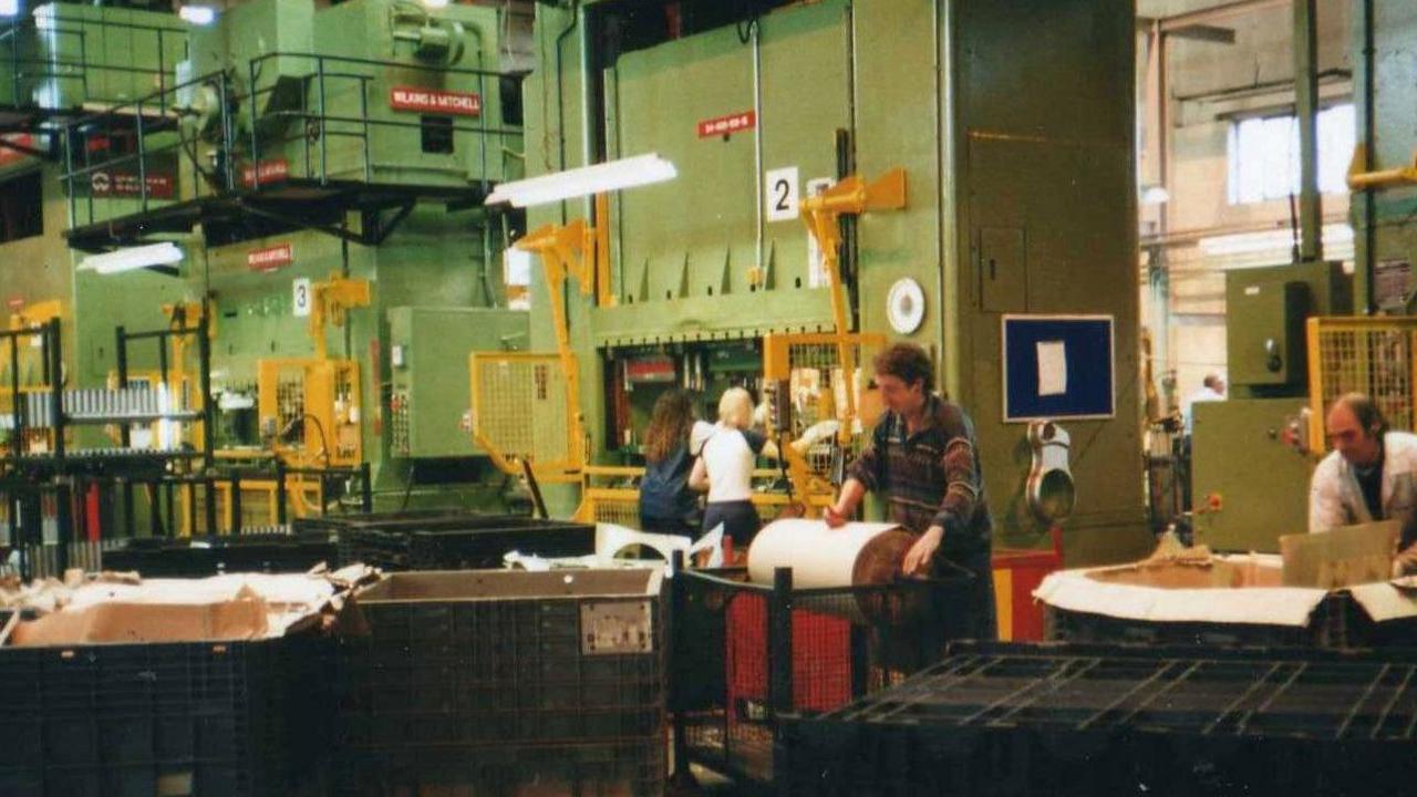 A large factory showing several people at work.