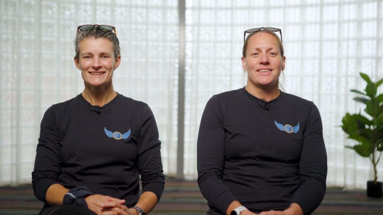 Georgina Gilbert and Rebecca Openshaw-Rowe sitting side by side in their Antarctic Fire Angels T-shirts