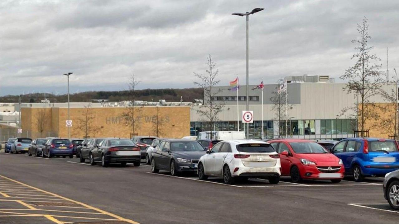 Concrete prison building with cars parked outside