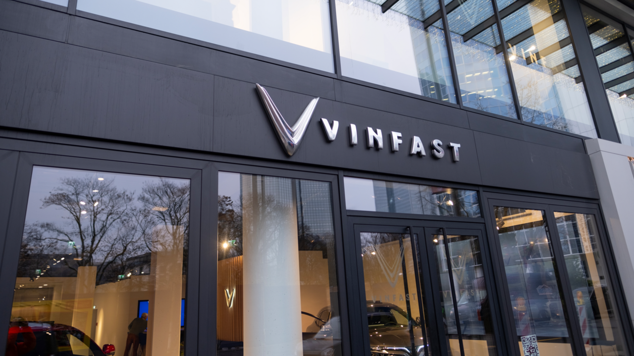 The front of a car showroom with black-framed windows and the words Vinfast in silver lettering above the doors