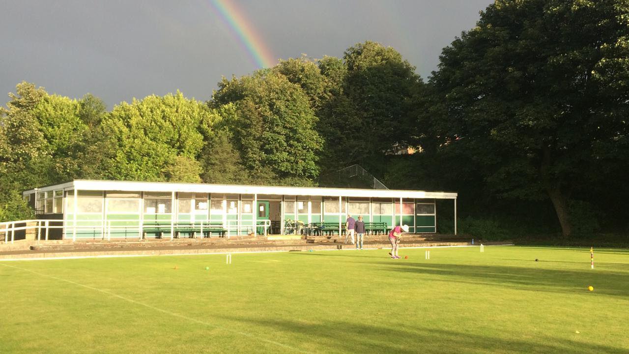 Shadows forming on a bowling green where people play croquet.