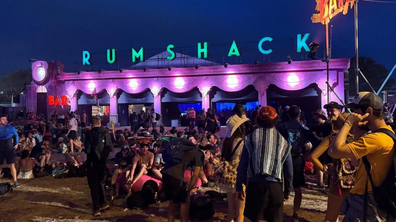 The Rum Shack - a building lit up with purple and pink lighting with the words Rum Shack in green on the roof.