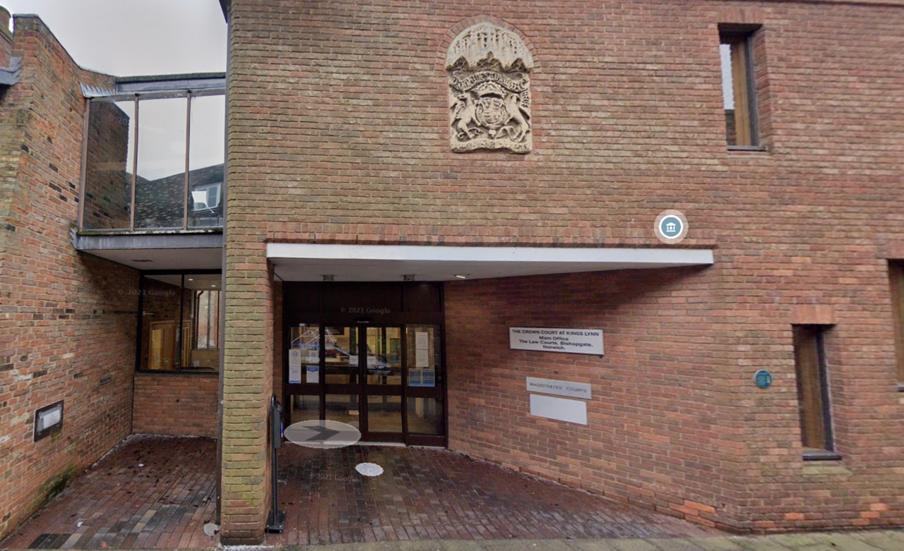 Photo shows brick building with entrance to King's Lynn Magistrates' Court with a royal crest above. 