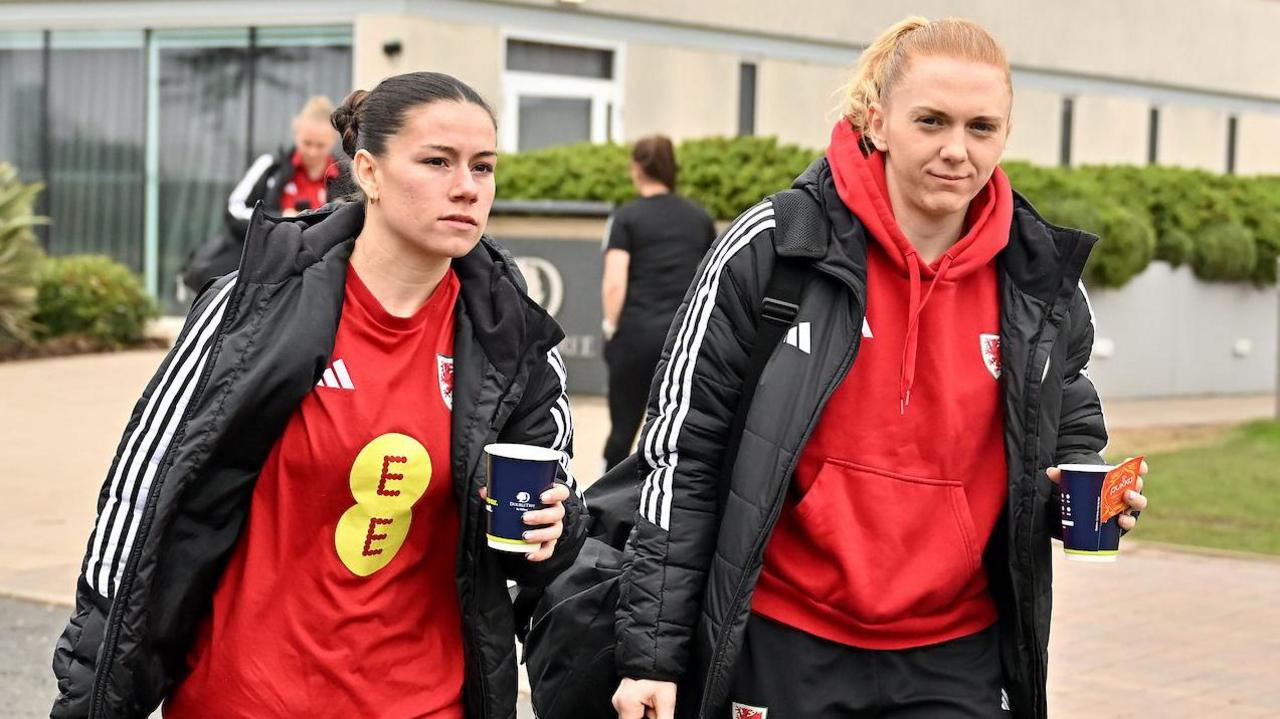 Ffion Morgan and Ceri Holland walking to get on board the Wales team bus 