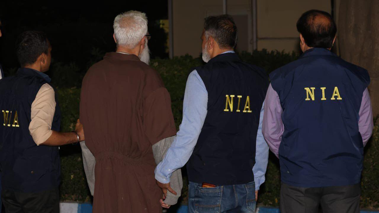A photo of Tahawwur Rana with officers from India's National Investigation Agency