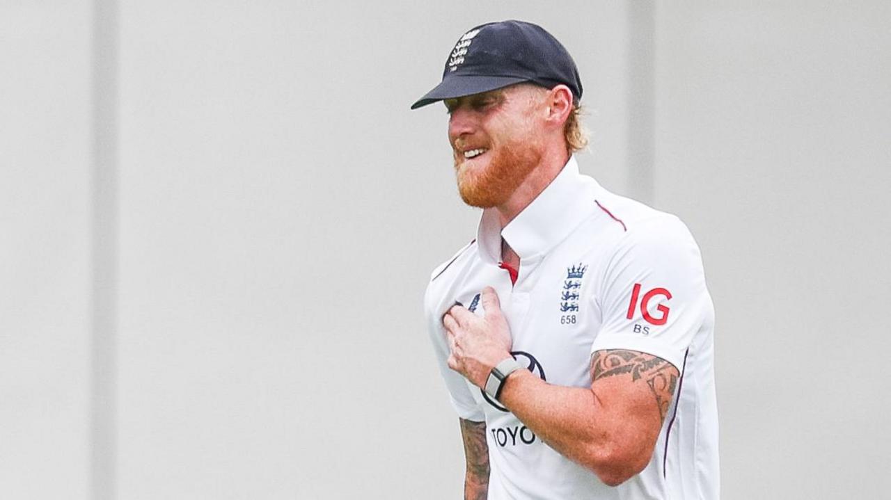England captain Ben Stokes prods between his right shoulder
