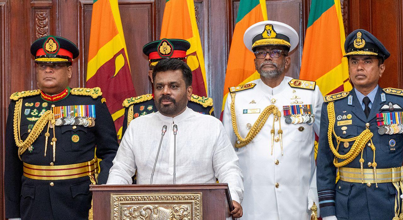 Sri Lanka's new president Anura Kumara Dissanayake speaks into a microphone alongside men in military clothes after he takes oath as president of Sri Lanka in Colombo, Sri Lanka on September 23, 2024. 