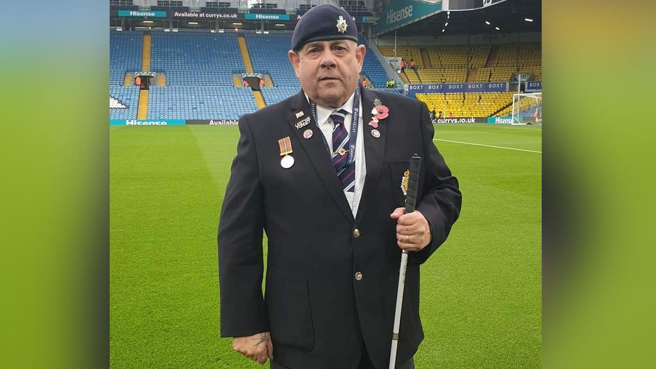 Chris Fella on the pitch at Elland Road. Mr Fella is wearing his blue military beret and medals, a blue jacket and regimental tie