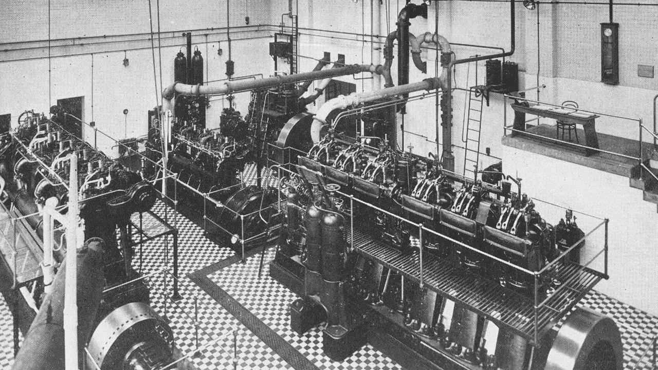 Black and white image of a large generator machinery inside a generator hall.