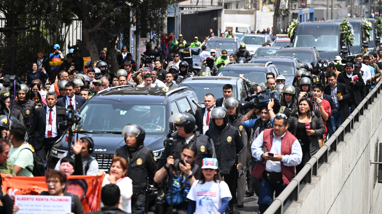 The hearse carrying the body of former president Alberto Fujimori is flanked by security, police, reporters and camera crews as a convoy of black vehicles make their way towards his funeral service,