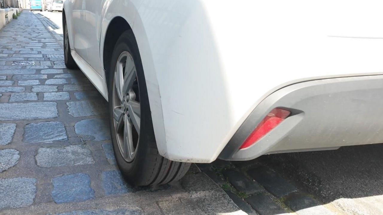 White car mounting a pavement