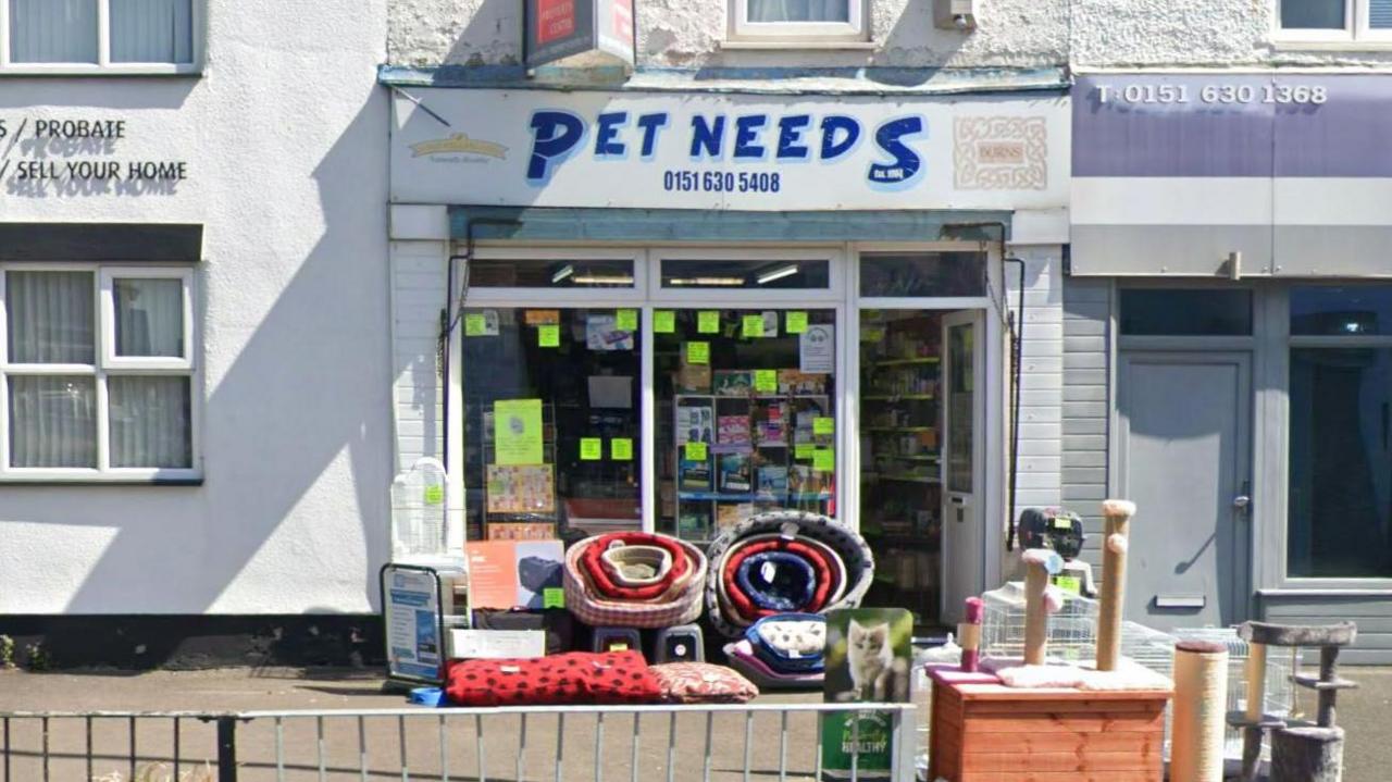 The frontage of Pet Needs on Liscard Crescent with pet supplies stacked outside the front