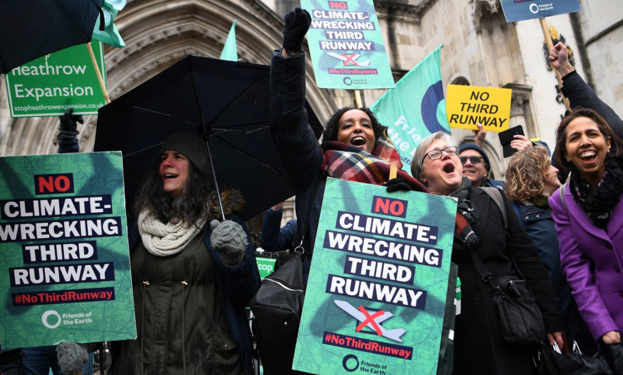 A group of protesters holding placards outside the High Court