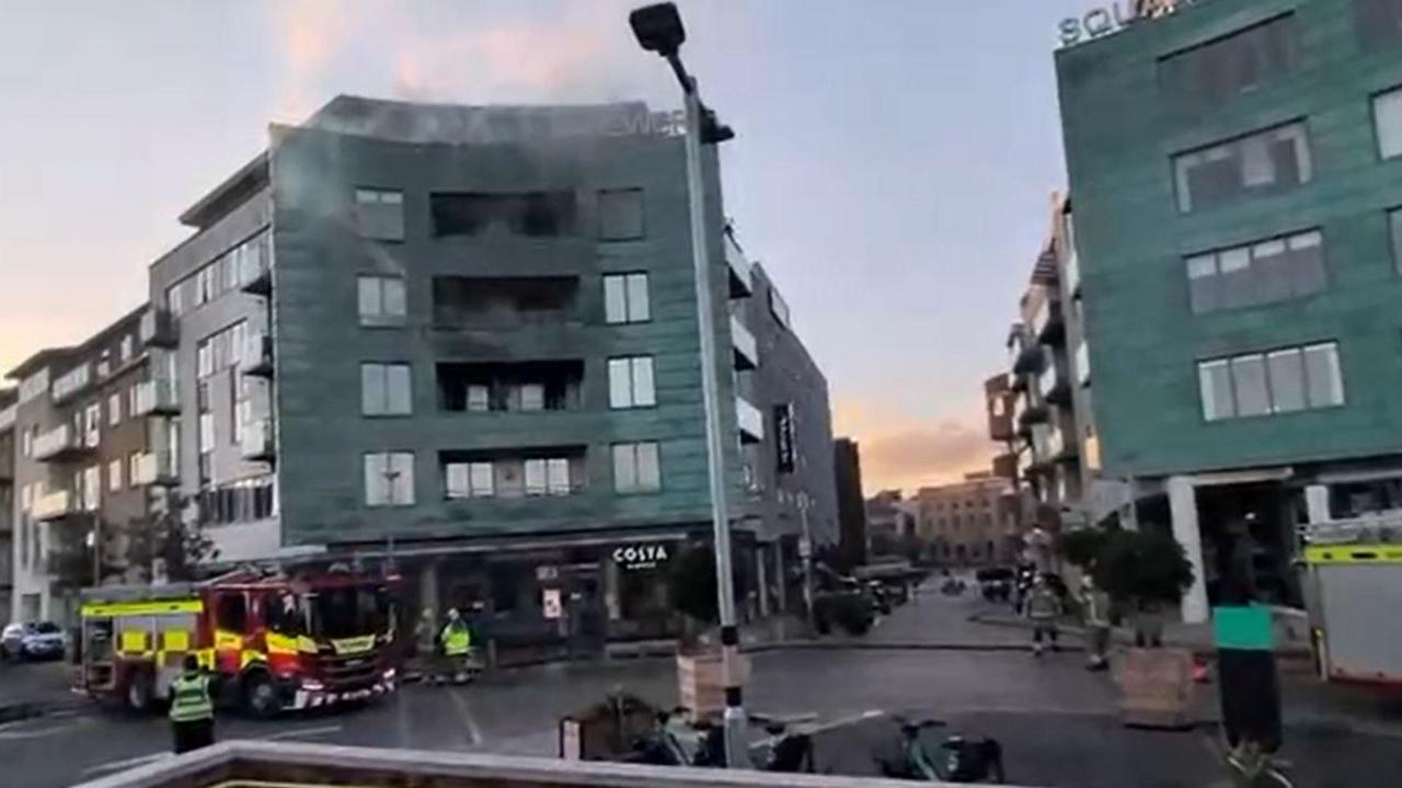 A general view of the scene of the fire at Copper Street in Dorchester on Friday. Firefighters and fire engines could be seen in front of the building. Smoke is rising from the affected unit.