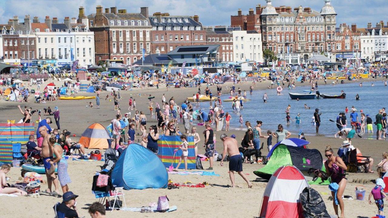 Crowds of people on Weymouth beach on a sunny summer's day