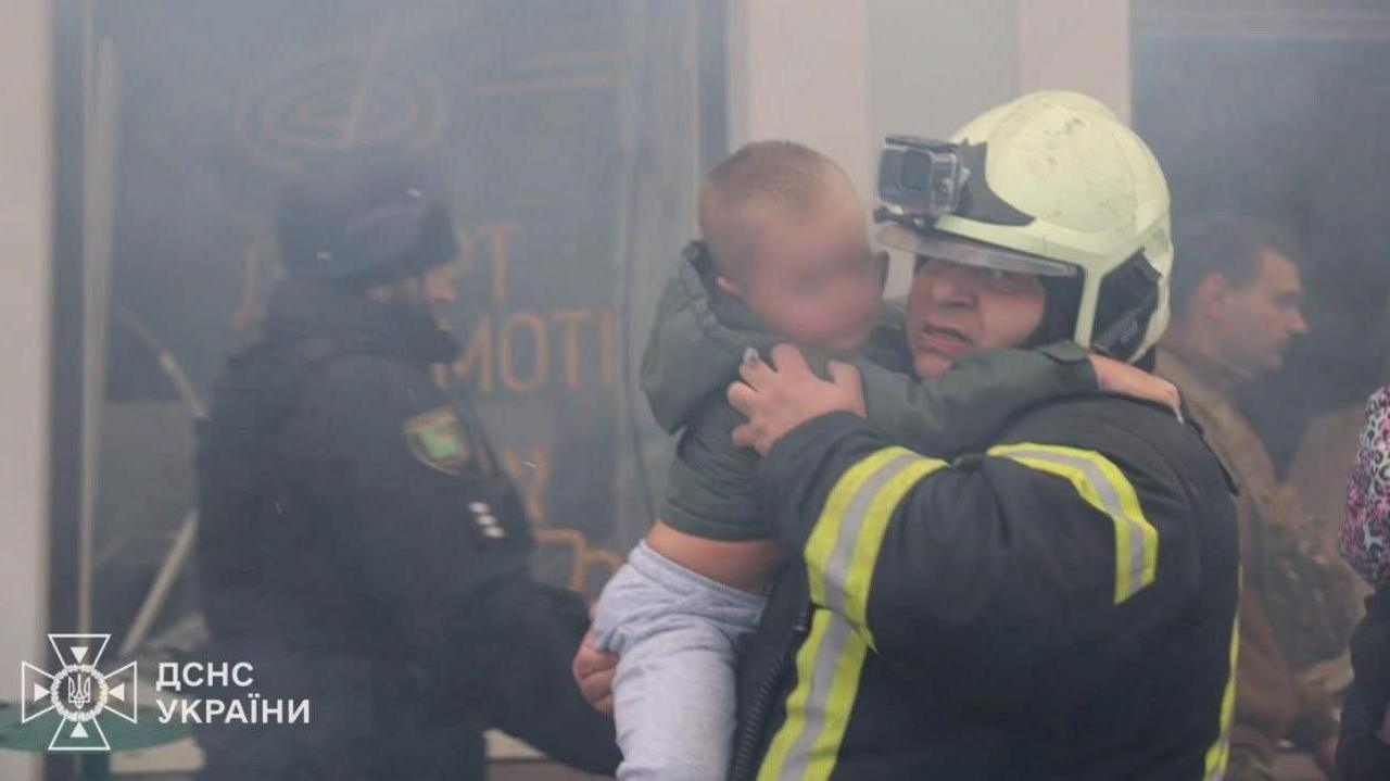 Fedir Uhnenko pictured rescuing a young boy from a kindergarten in Kharkiv