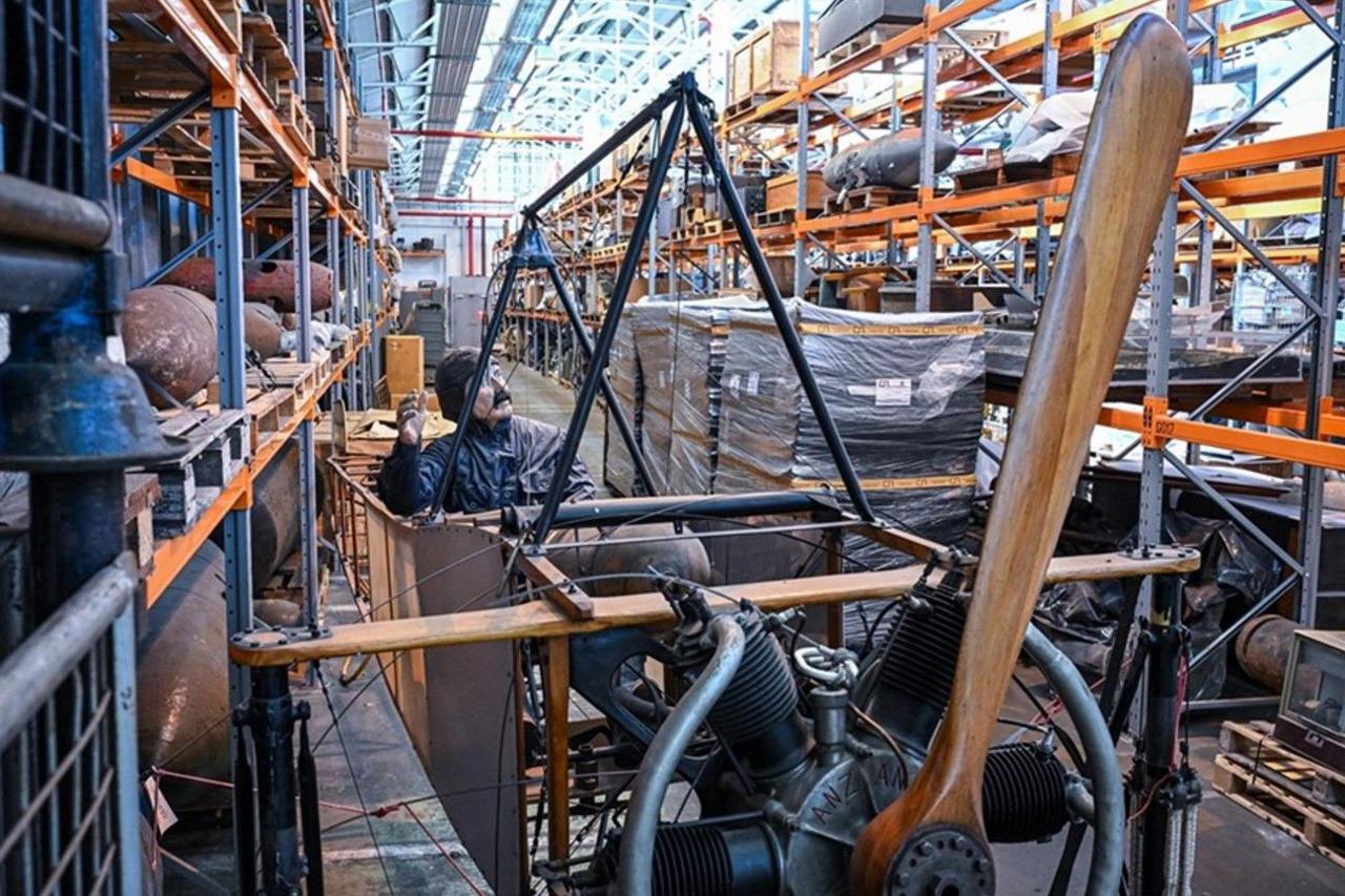 A large piece of military equipment is in the middle, with shelves to the left and right.
