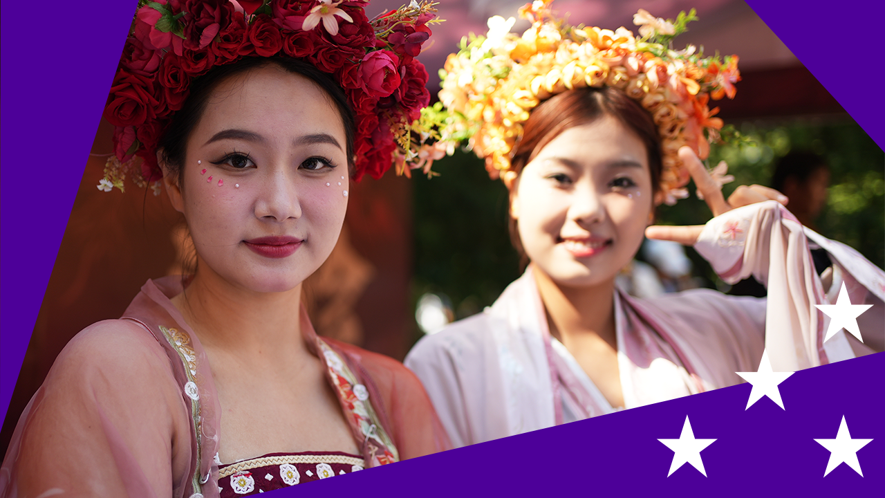 Two Chinese women in traditional dress, with stylised purple border dotted with four white stars