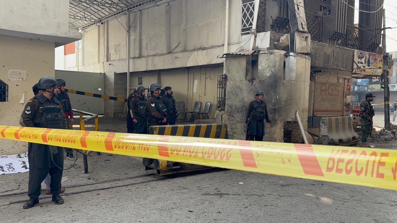 Part of the Federal Constabulary headquarters in Peshawar cordoned off with yellow tape after a suicide bomb attack. Security officers armed with guns are seen on site