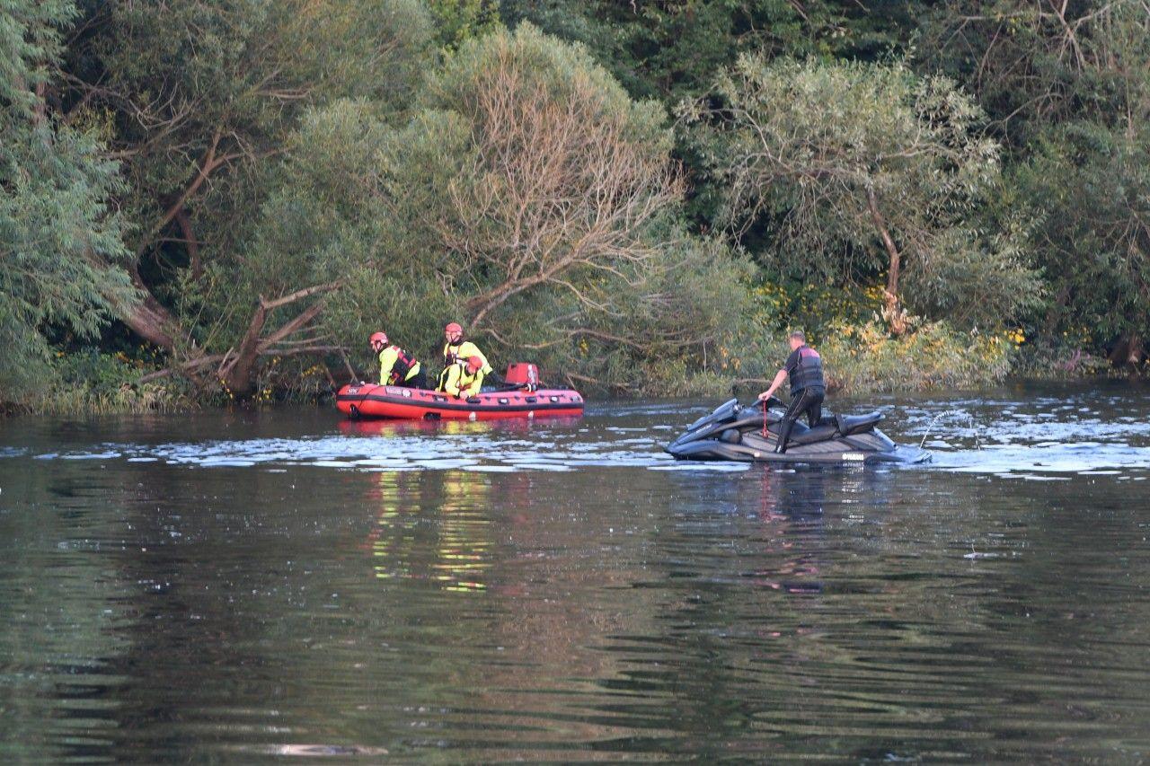 A police search on a river with a jet-skier and officers on an inflatable dinghy