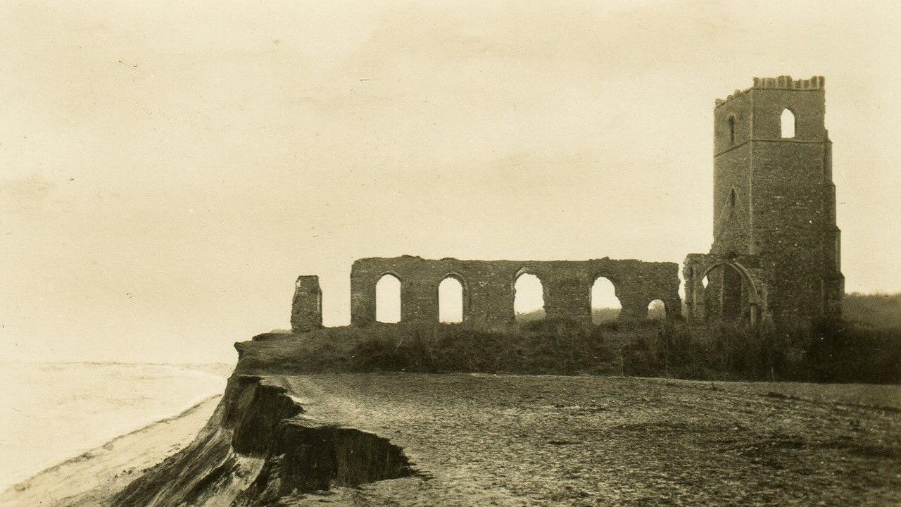 A sepia image of the ruins of All Saints Church, in Dunwich, on an eroded coast