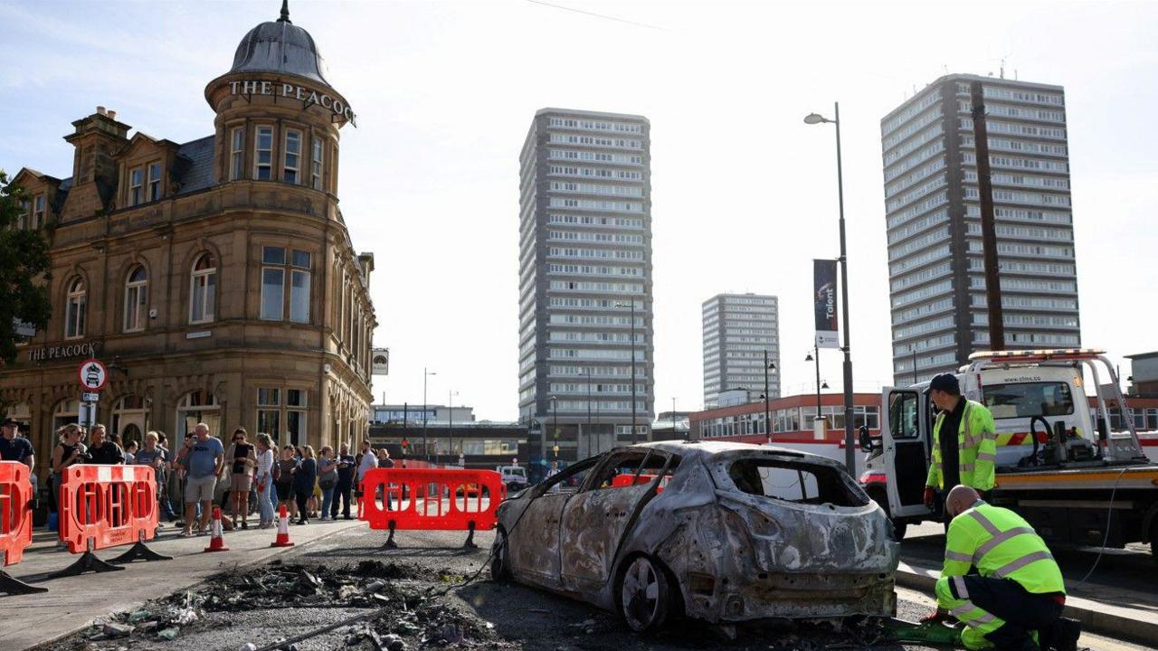 People gathered around a burnt car in Sunderland city centre on Saturday