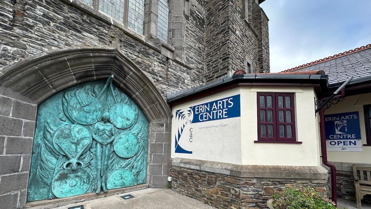 The entrance of the Erin Arts Centre, with an engraved sculpture. a sign reads Erin Arts Centre.