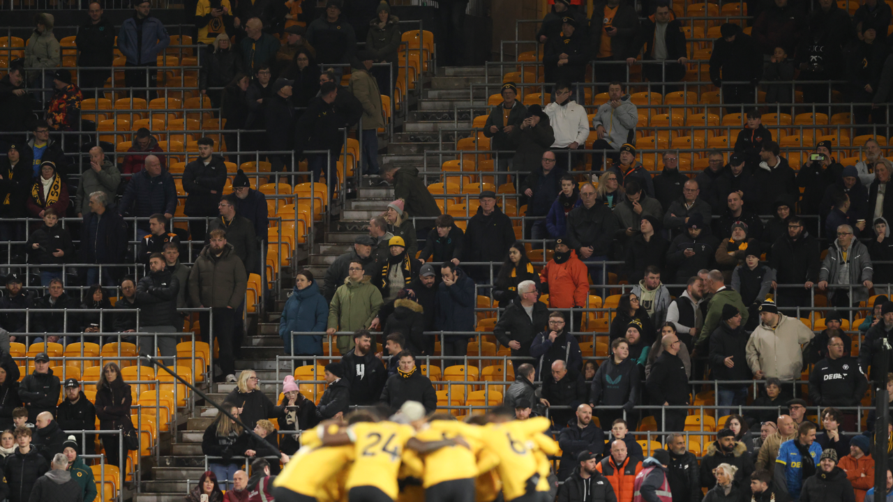 Empty seats visible behind the Wolves team huddle