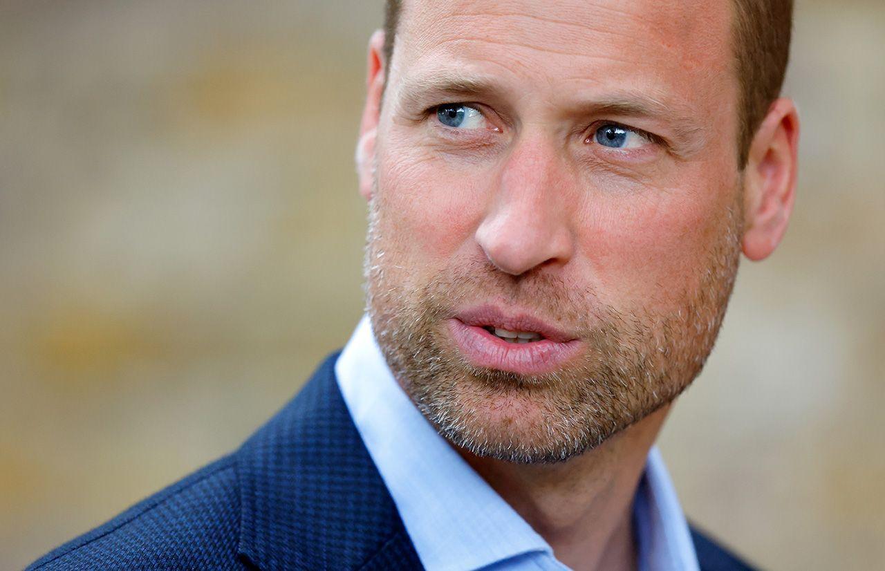 Prince William, head and shoulders photo as he looks away from camera wearing a suit and blue shirt with an out-of-focus beige background, pictured in London in September 2024.