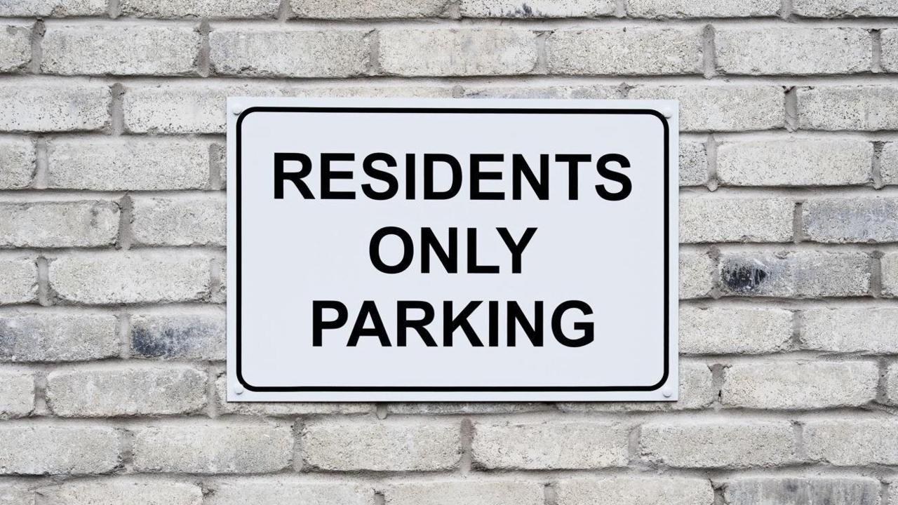 A white sign which says residents only parking