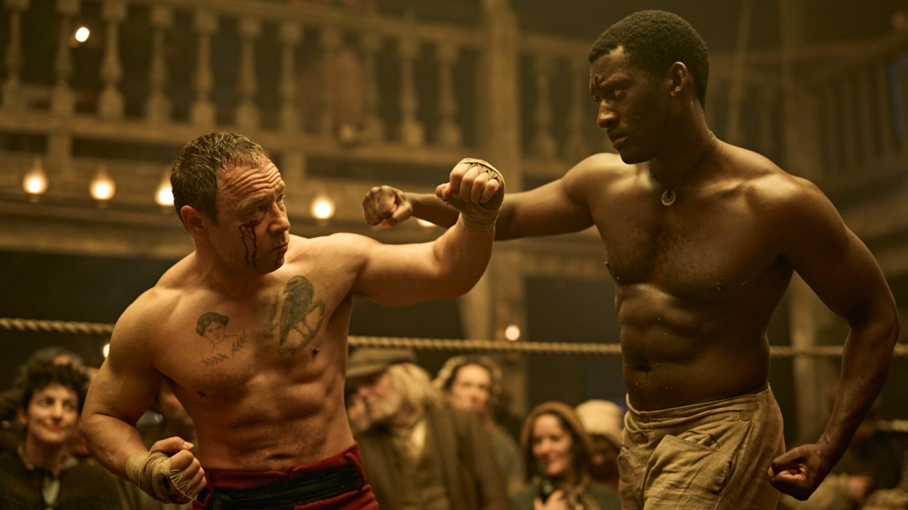 Stephen Graham's character Sugar Goodson (left) wears red boxing shorts and has a cut on his right eye as he fights boxer Hezekiah Moscow, played by   Malachi Kirby (right)