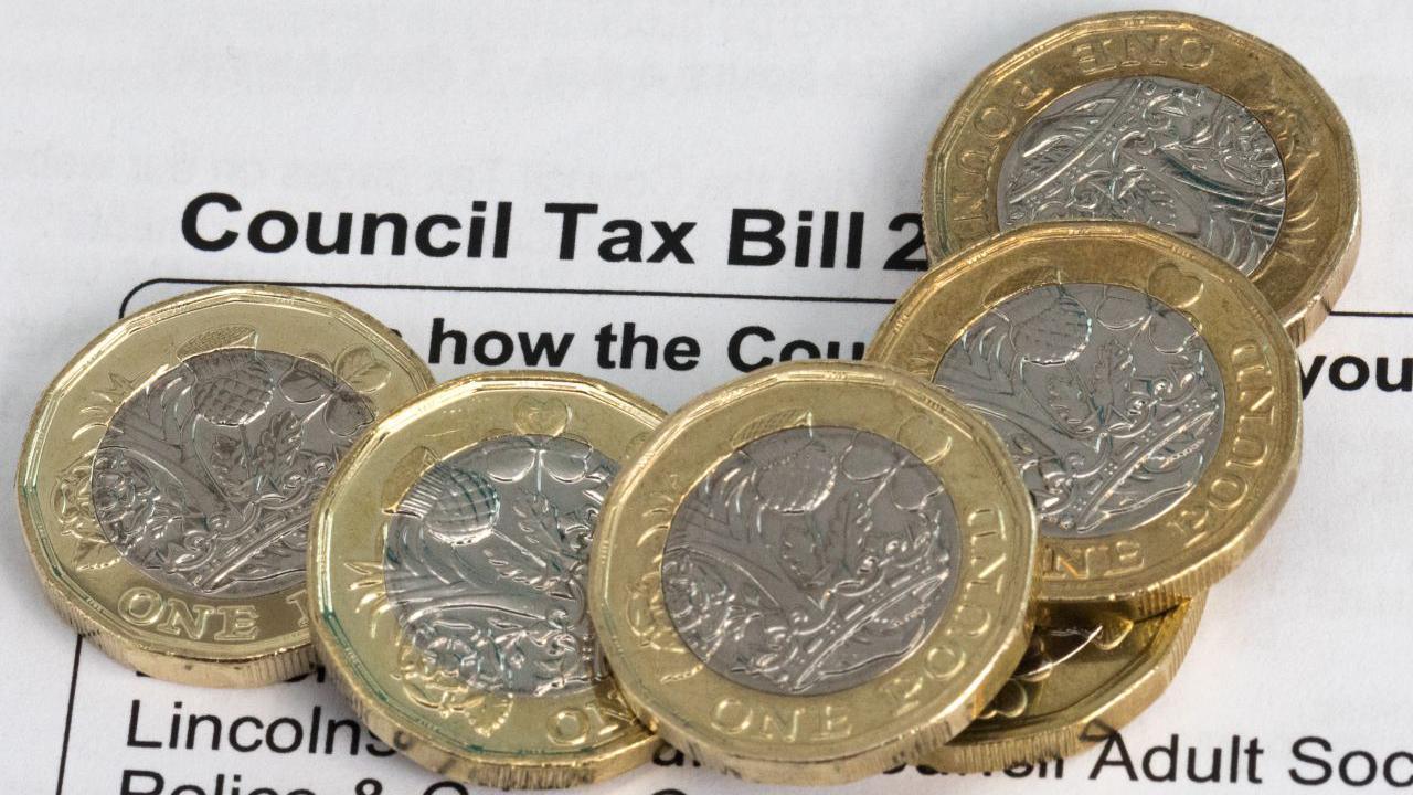 Five pound coins on a council tax bill 